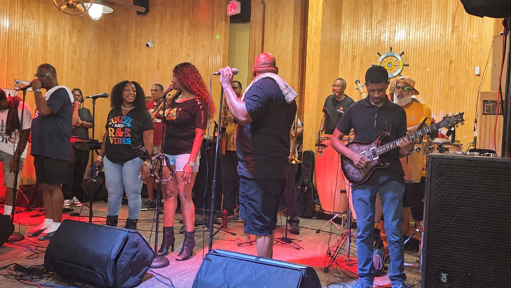 Nice & Smooth Music Group on stage — vocalists at the microphones with guitar and percussion behind them